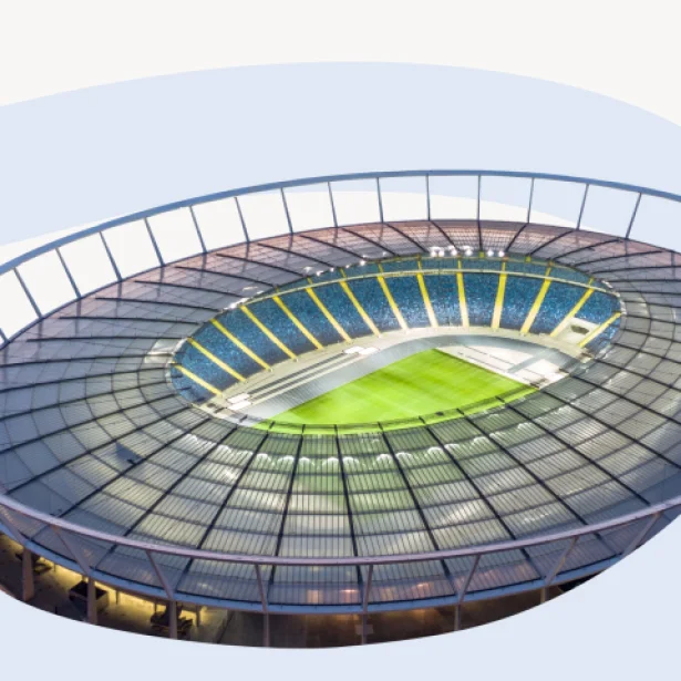 "Widok z wnętrza Stadionu Śląskiego na niebieską bieżnię lekkoatletyczną oraz murawę piłkarską. Trybuny w kolorach niebieskim i żółtym otaczają boisko pod przezroczystym zadaszeniem."