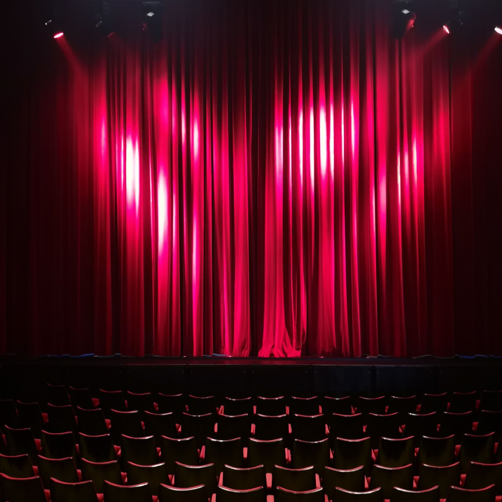 zdjęcie czerwonej teatralnej kurtyny i krzesła na widowni