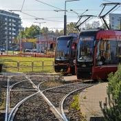 Dwa nadjeżdżające czerwone tramwaje