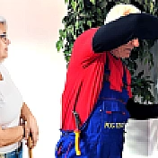 Mężczyzna wykonujący naprawę i kobieta patrząca na niego