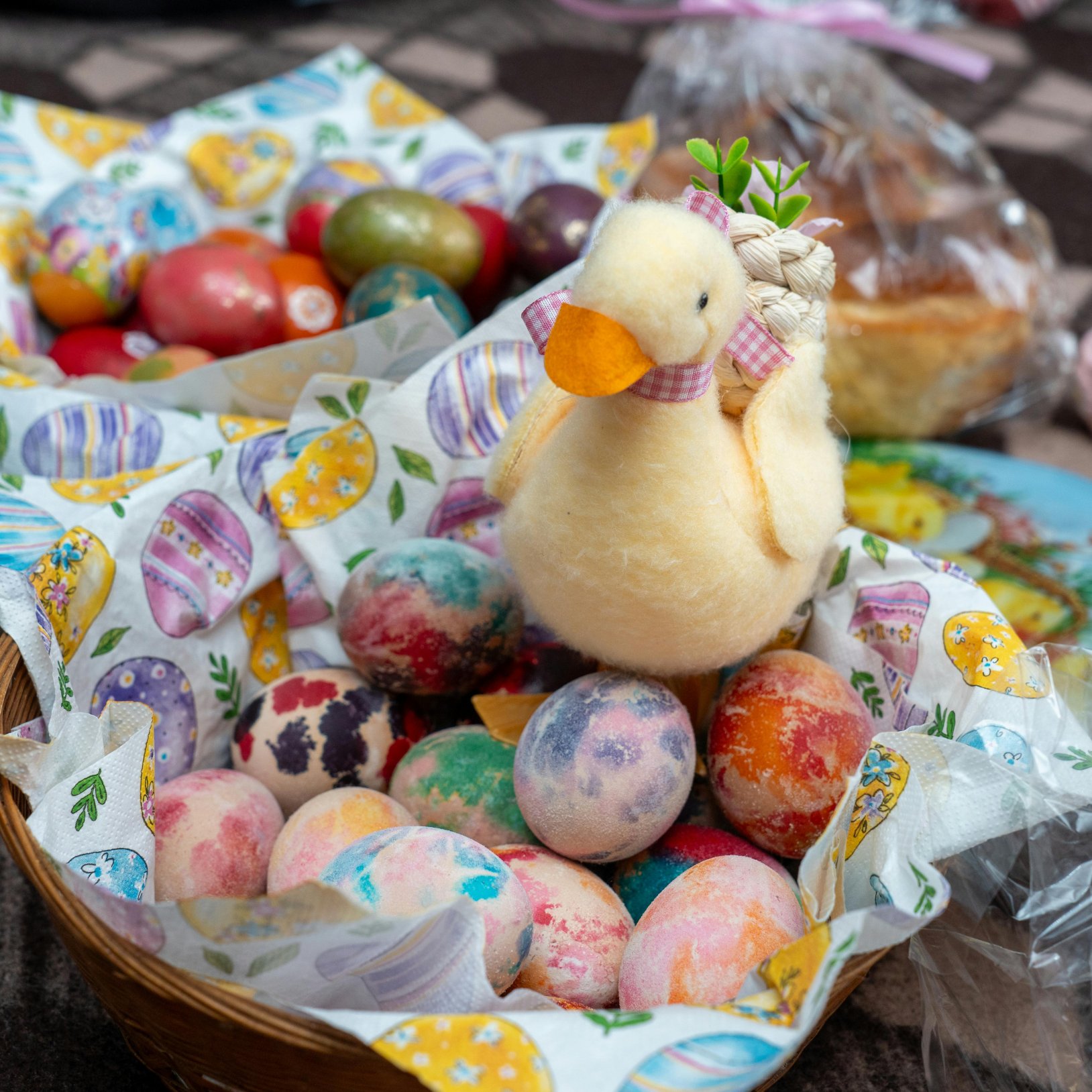 wielkanocna figurka kaczki wśród kolorowych pisanek