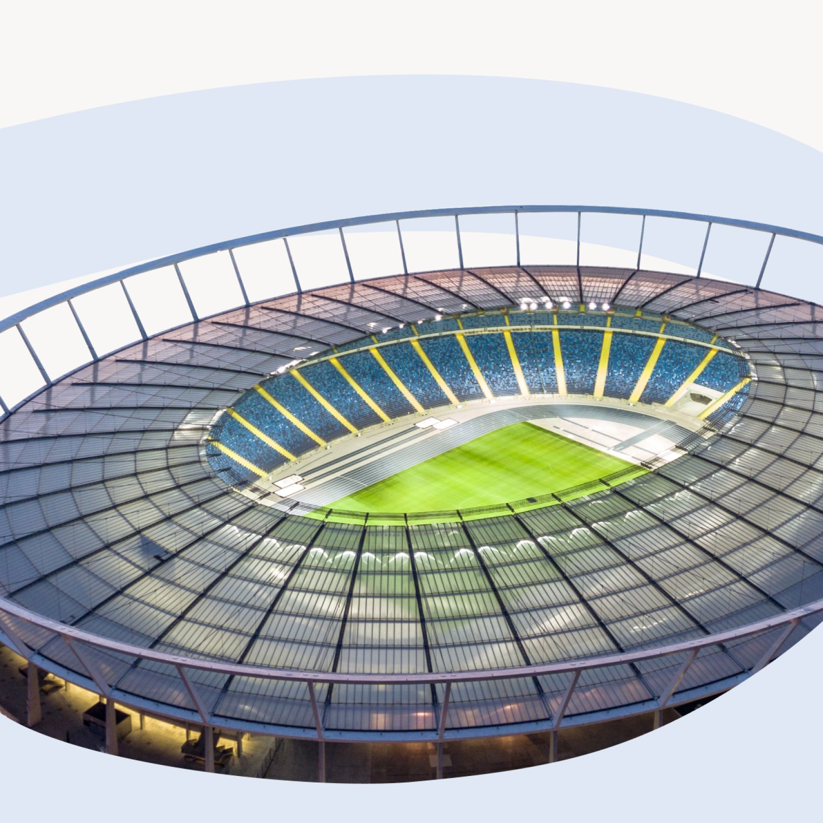 "Widok z wnętrza Stadionu Śląskiego na niebieską bieżnię lekkoatletyczną oraz murawę piłkarską. Trybuny w kolorach niebieskim i żółtym otaczają boisko pod przezroczystym zadaszeniem."