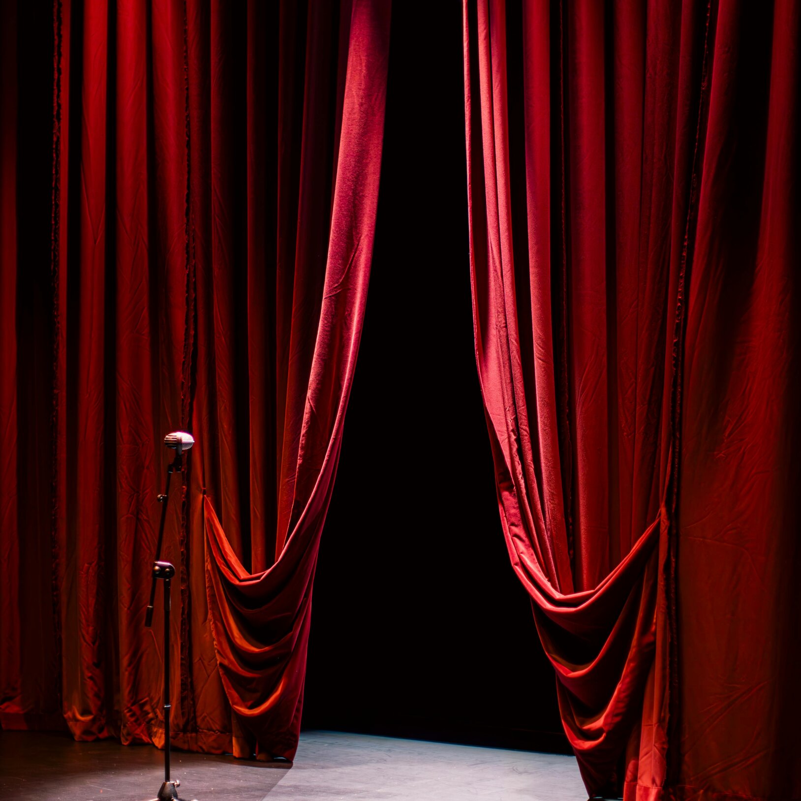 zdjęcie teatralnej sceny z kurtyną i mikrofonem