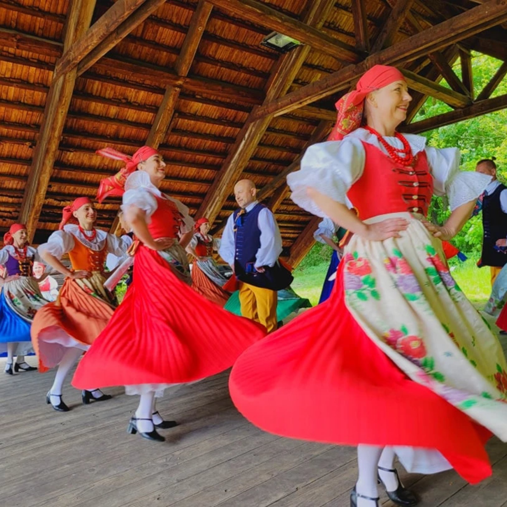 kobiety tańczące w strojach regionalnych w skansenie