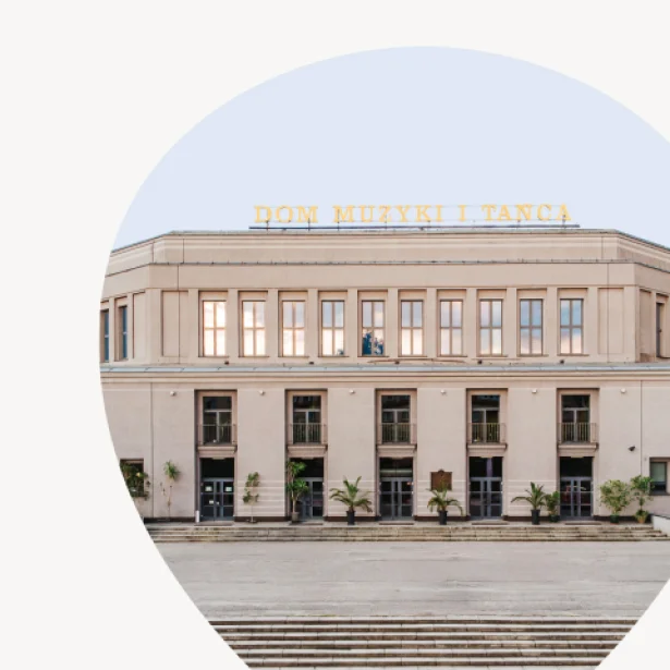 Frontowa elewacja jasnego, modernistycznego budynku z symetrycznymi oknami i wysokimi wejściami; na dachu widoczny napis „DOM MUZYKI I TAŃCA”, przed budynkiem stoją donice z roślinami i szerokie schody, a kadr jest ujęty w okrągłym wycięciu na jasnym tle.