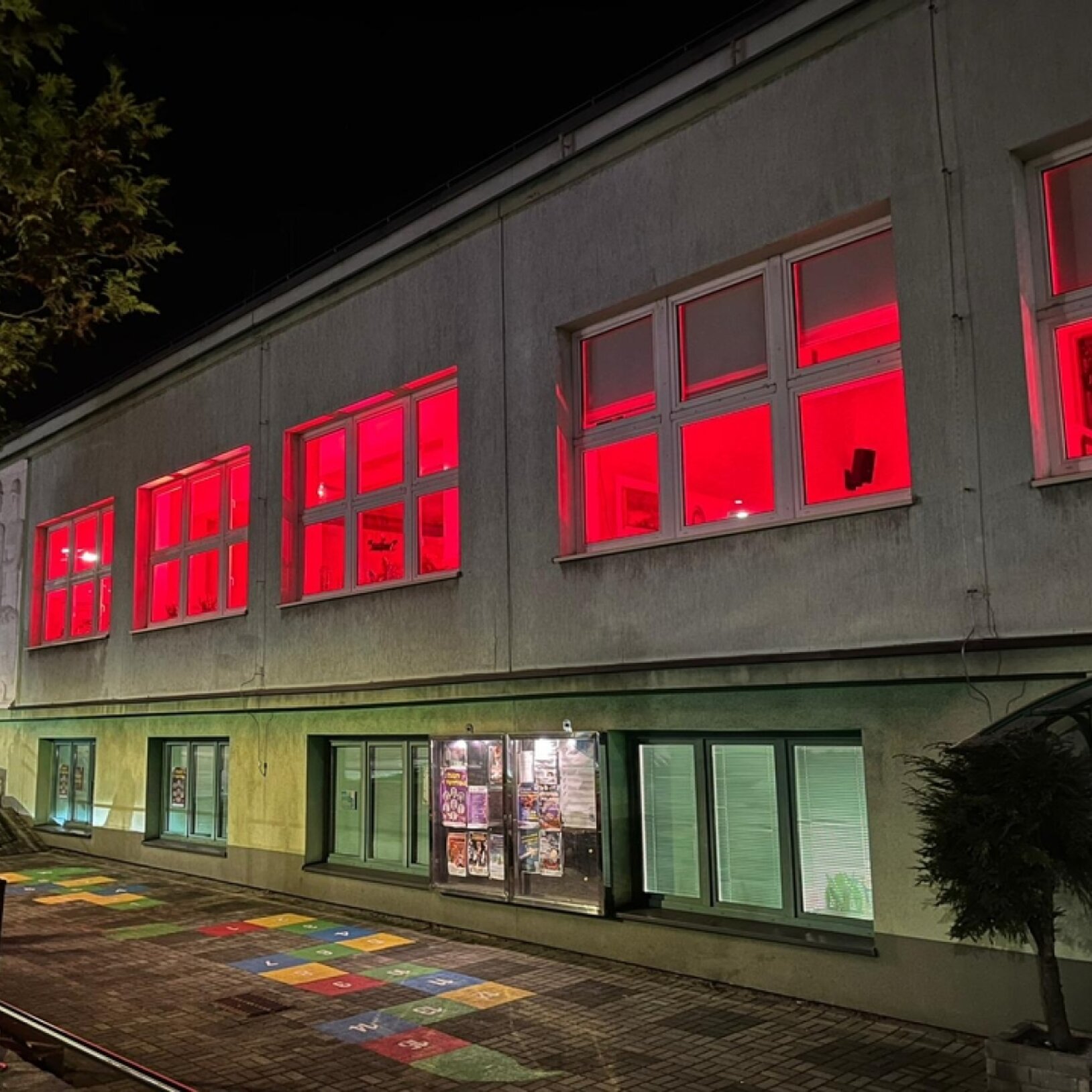 zdjęcie budynku MOK Radlin w nocy, z oświetlonymi od wewnątrz oknami