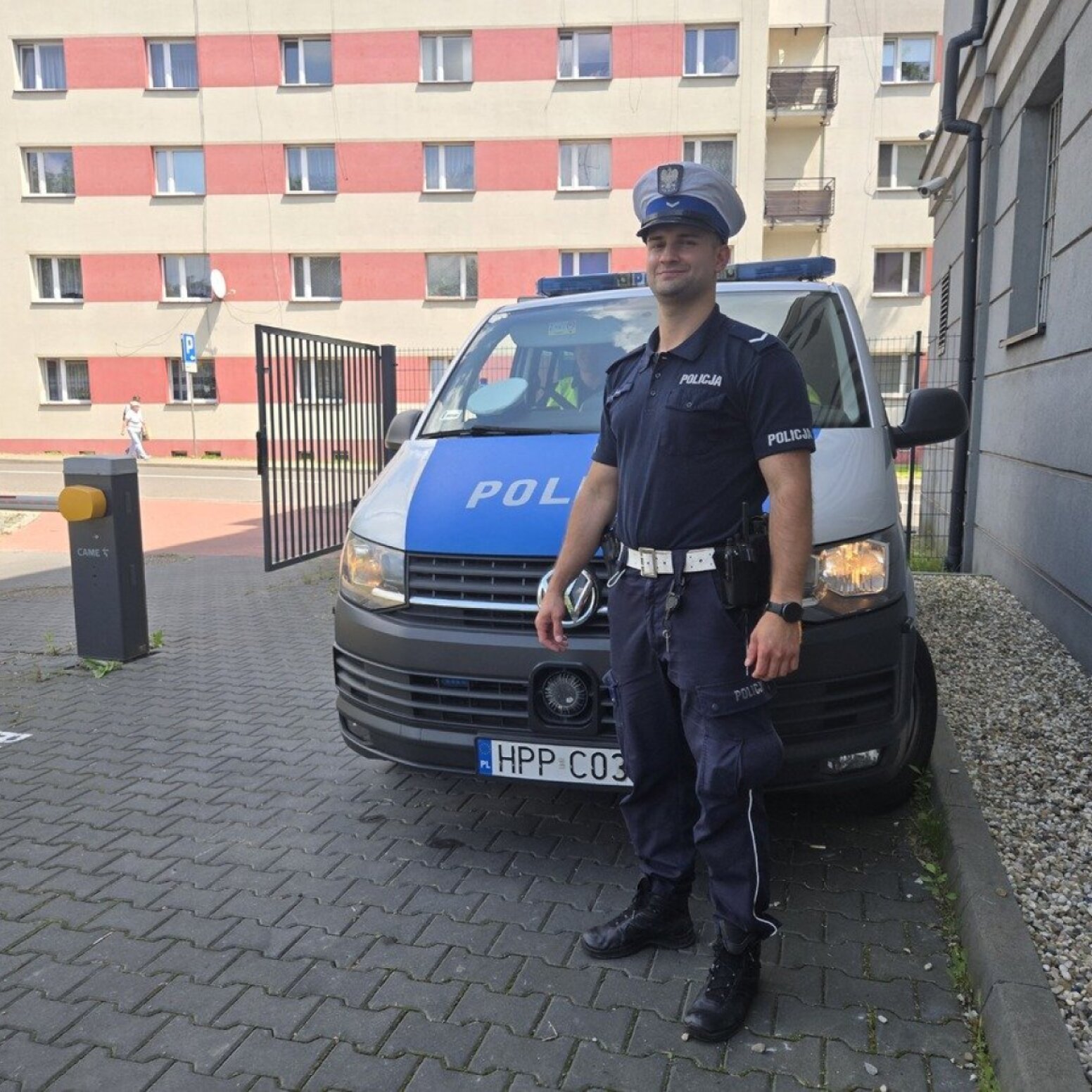 Policjant na tle radiowozu