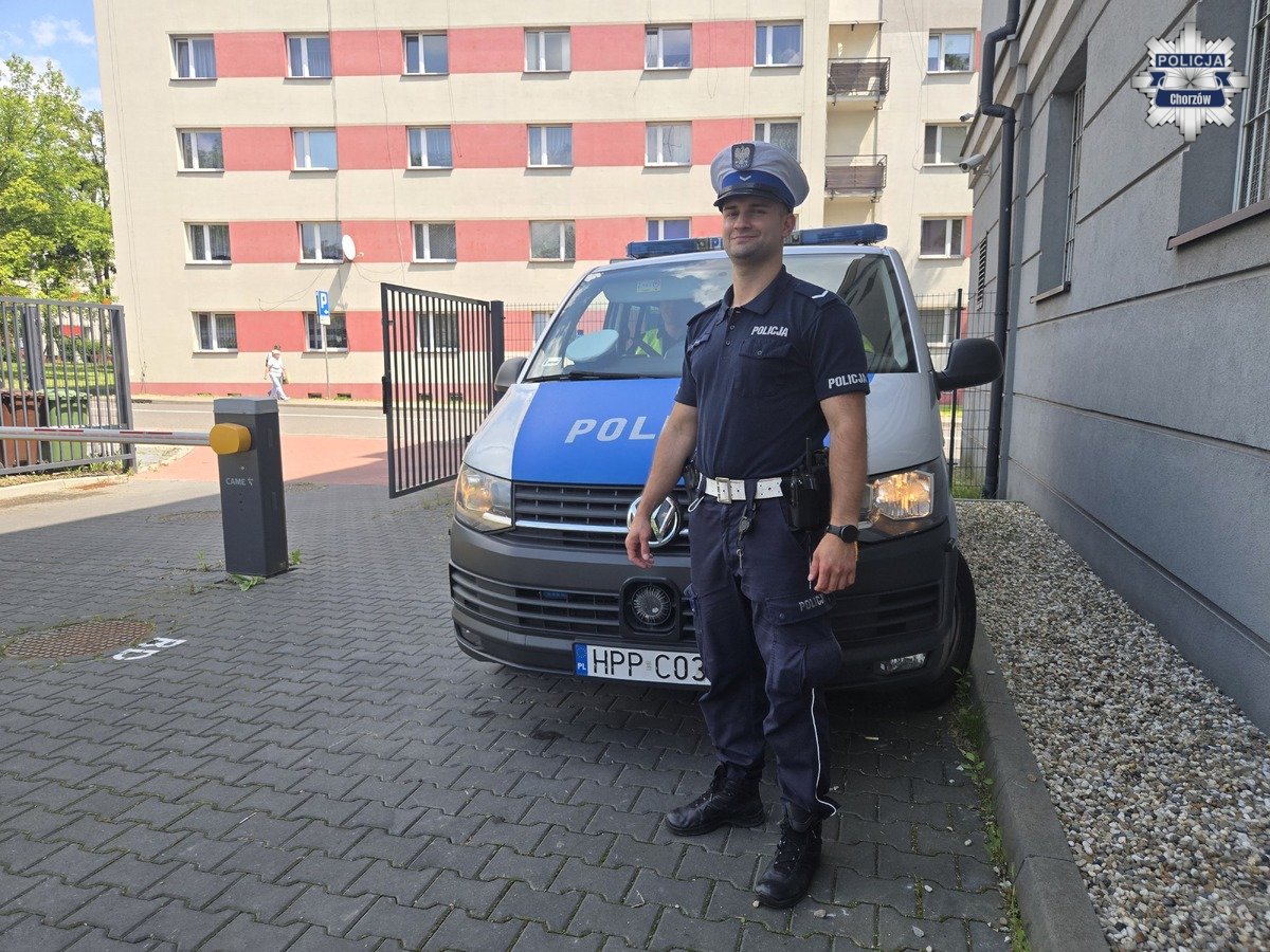 Policjant na tle radiowozu