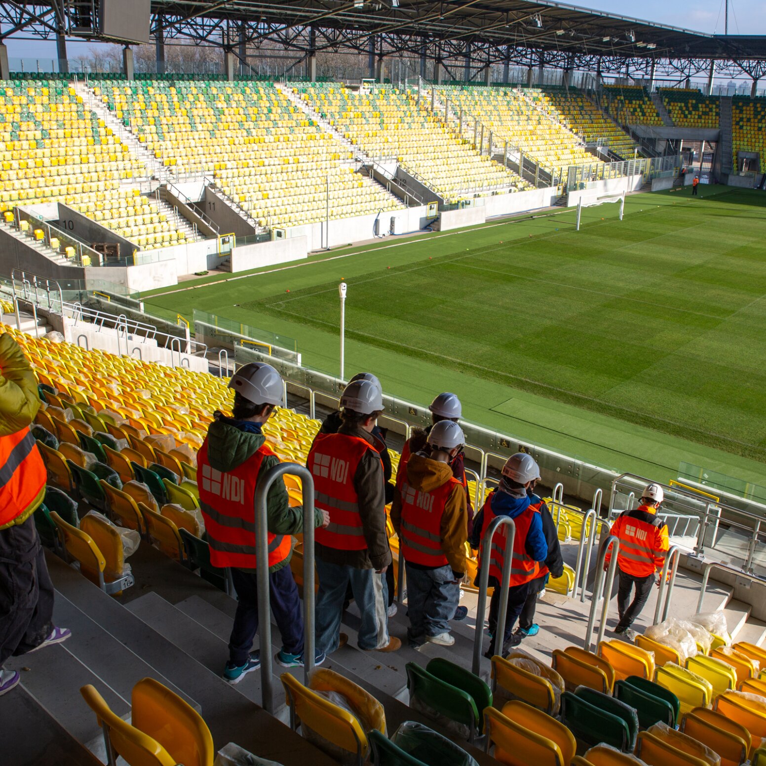 Uczniowie w strojach pracowniczych na stadionie
