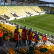 Uczniowie w strojach pracowniczych na stadionie