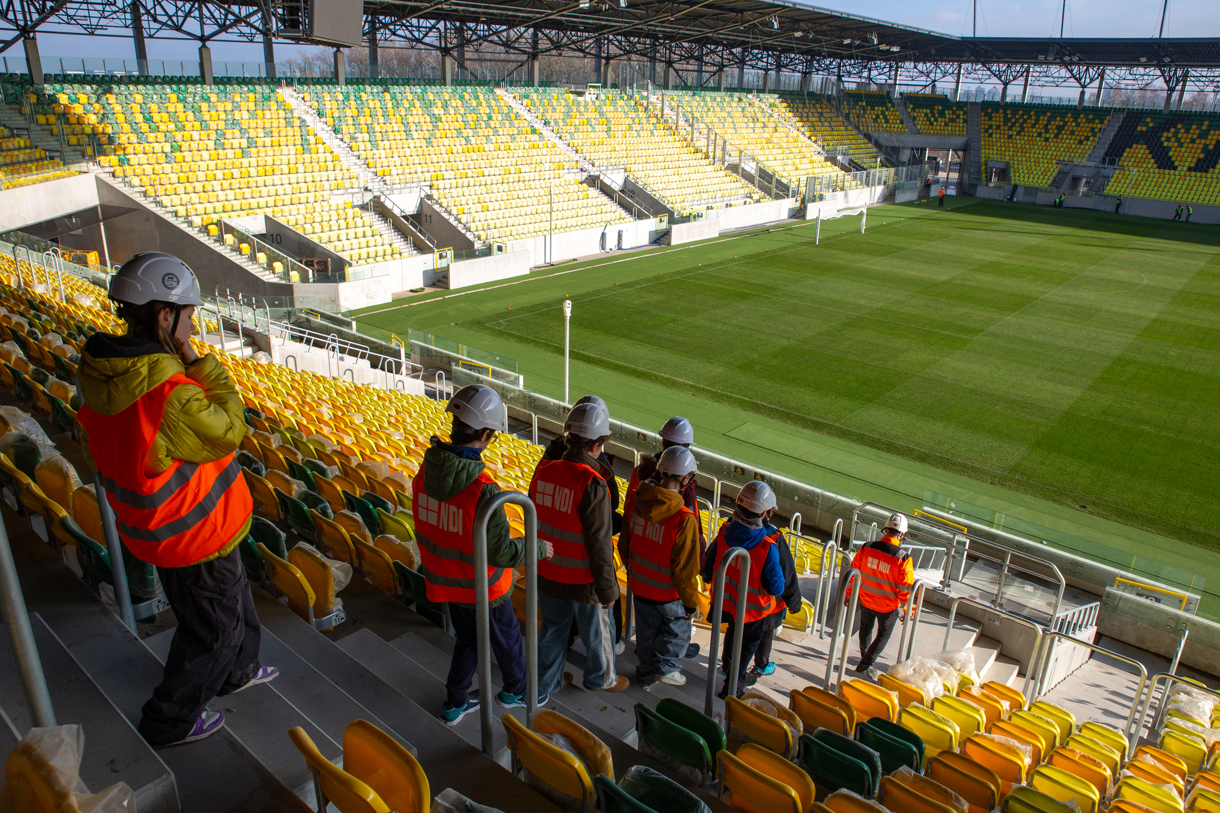 Uczniowie w strojach pracowniczych na stadionie